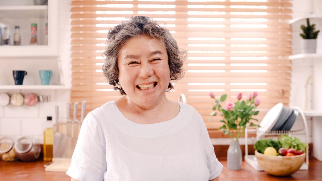 Asian elderly woman feeling happy smiling and looking to camera.